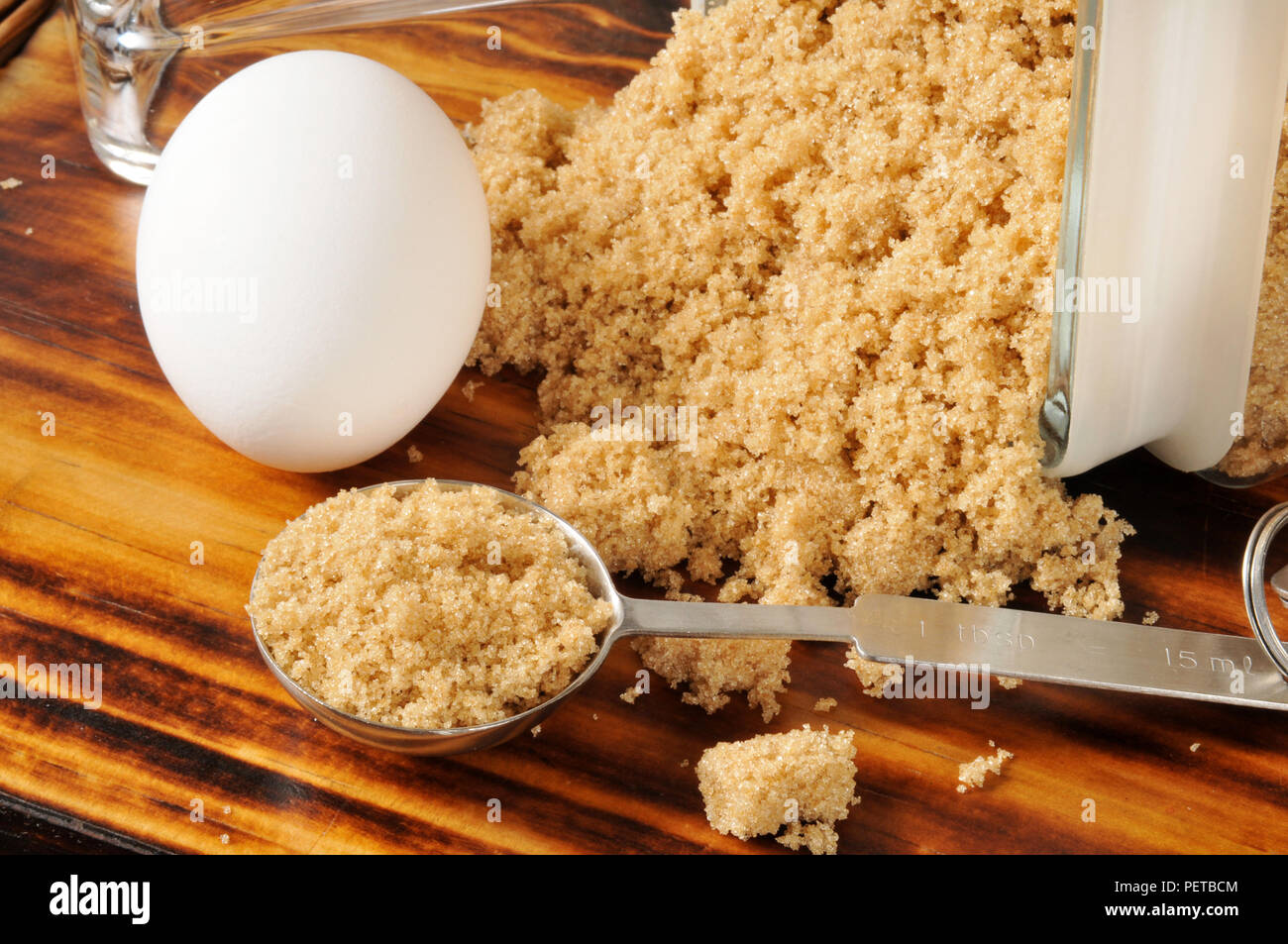 A measuring spoon of brown sugar with an egg Stock Photo Alamy