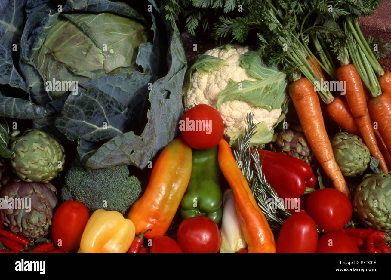 Assorted harvested fresh vegetables including carrots, cabbage, cauliflower, globe artichokes, capsicums and tomatoes Stock Photo