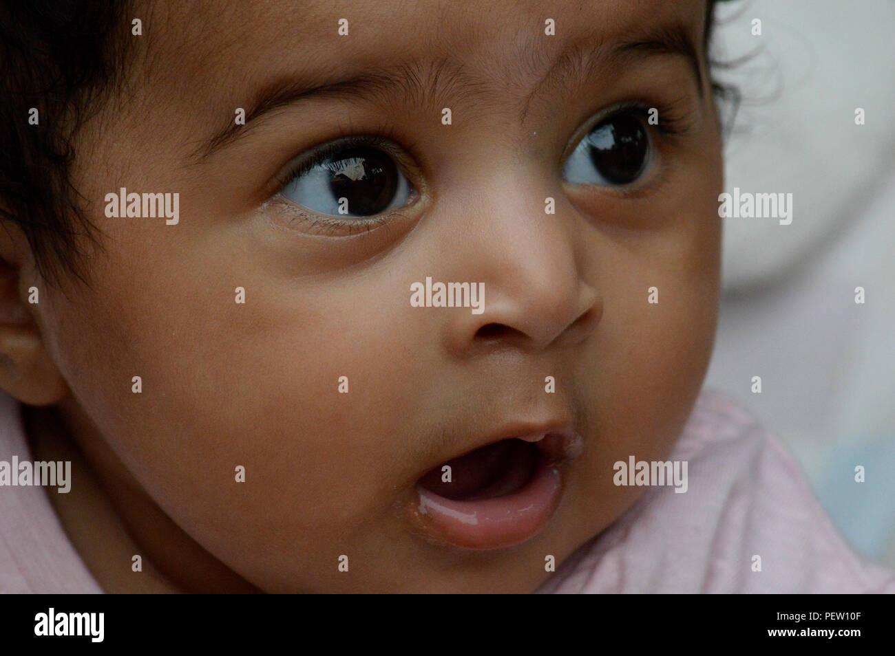 Infant's close up of am adorable very expressive big eyed cute Indian's delightful face a real treasure and pleasure to look at. Stock Photo