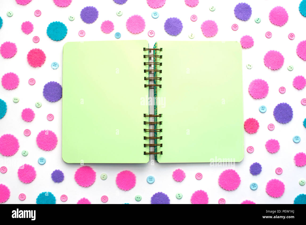 Open Notepad green pages on colored confetti background. Top view flat lay Stock Photo