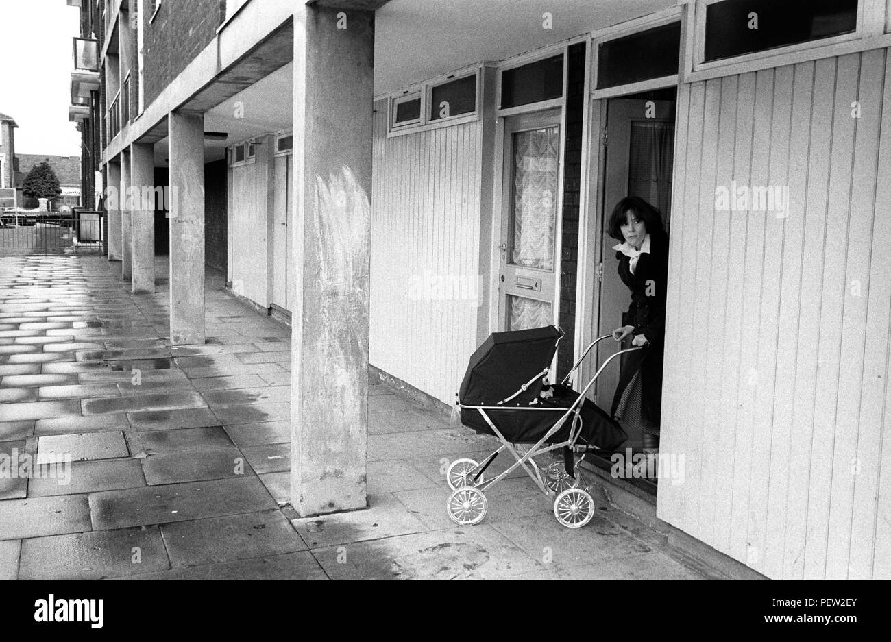 1970s motherhood London Council Estate Housing. Young mother with pram leaving her flat Hoxton 70s England HOMER SYKES Stock Photo