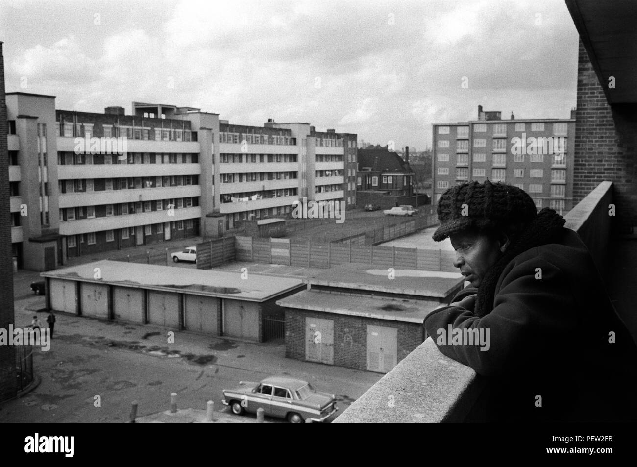 1970s poverty in Britain, an elderly black British woman in her council estate flat balcony on the Stonebridge Estate.  Isolated and living alone in a single room plus small kitchen and bathroom. All in very bad condition, the flat is damp and very cold.  Haggerston, East London, England 1978. 70s HOMER SYKES Stock Photo