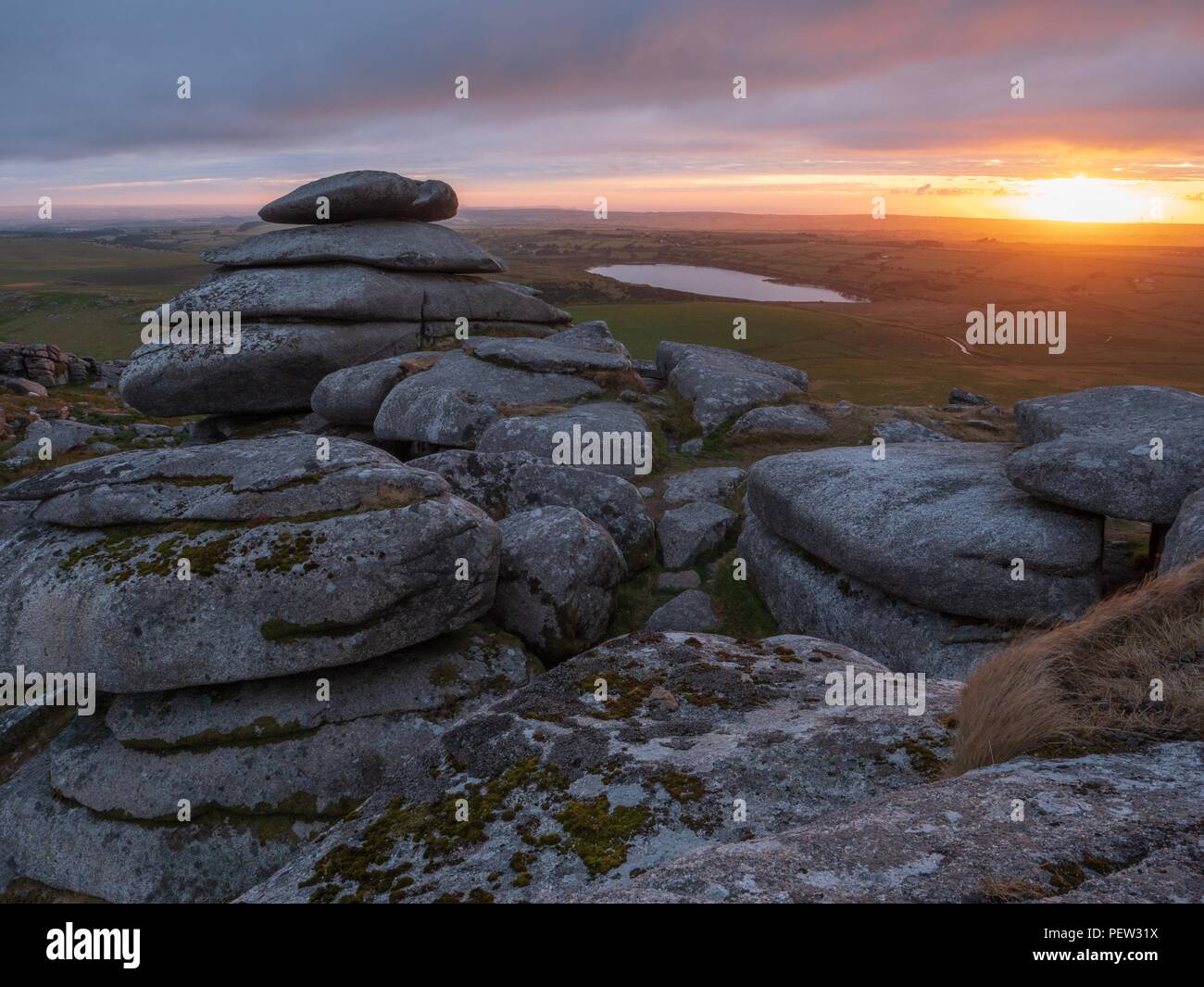 A view towards the setting sun from stones of Rough Tor in Bodmin, Cornwall Stock Photo