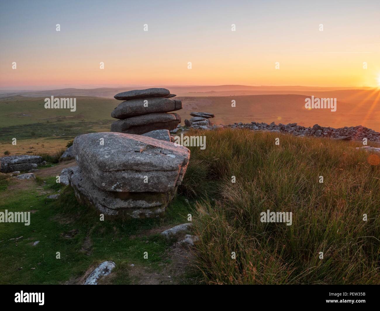 The view towards the setting sun from the stones of the Cheesewring on Bodmin Moor in Cornwall Stock Photo