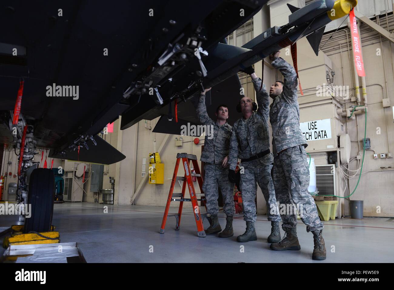 From left, Senior Airman Aaron Miller, Tech Sgt. Michael Wallace and Senior Airman Jordan Wilson, 4th Aircraft Maintenance Squadron weapons load technicians, install a munition on an F-15E Strike Eagle during the Load Crew of the Year competition, Jan. 15, 2016, at Seymour Johnson Air Force Base, North Carolina. Each aircraft maintenance unit fielded teams of three Airmen who participated in the competition for training, morale and bragging rights. (U.S. Air Force photo/Senior Airman John Nieves Camacho) Stock Photo