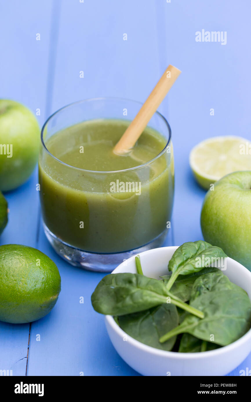 Healthy green smoothie drink with straw on blue table background Stock ...