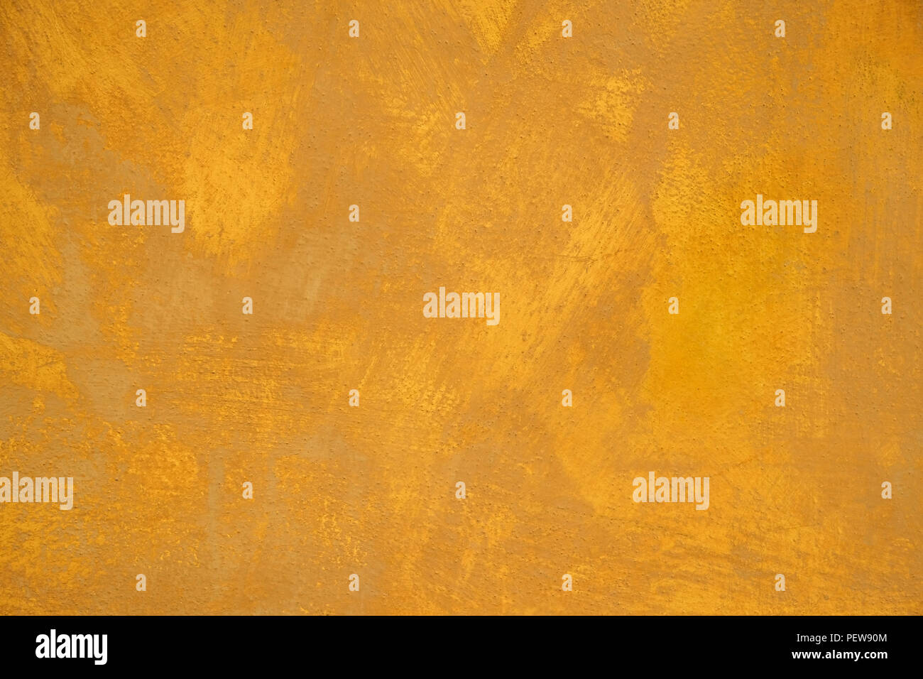 Old stucco plaster yellow painted wall abstract background Stock Photo