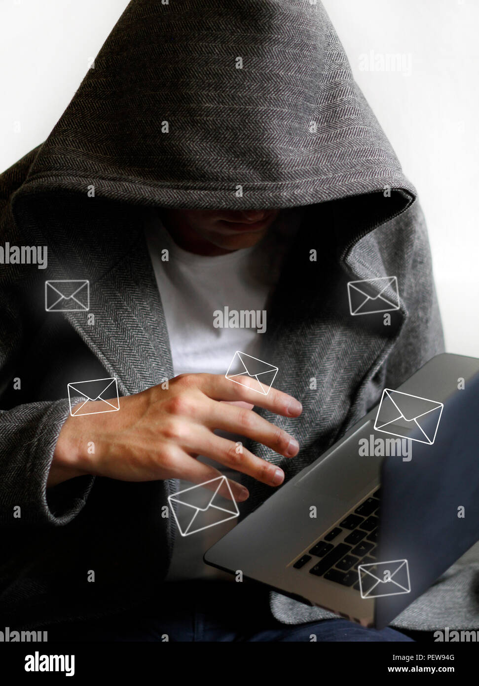 Spam mail and hacker holding laptop Stock Photo