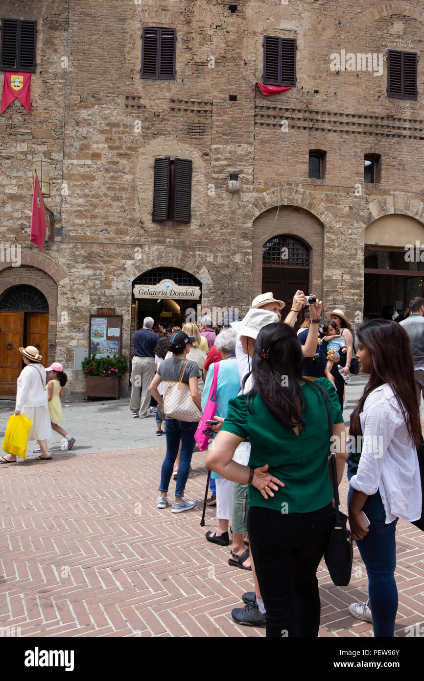 Tourists are standing in line for Gelateria Dondoli in San Gimignano, Tuscany, Italy Stock Photo