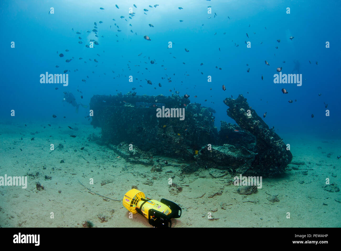 Two divers (MR) with underwater scooters explore a WW II landing craft