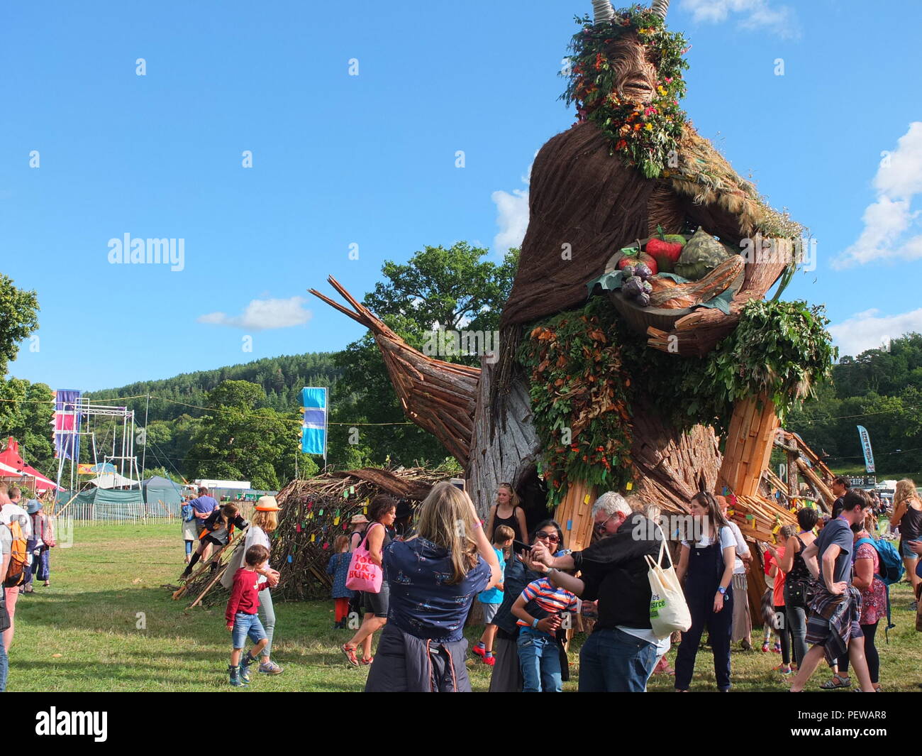 Impressive Green Man sculpture built by Pyrite Creative for the Green Man festival held in Wales. Family taking selfie in front of the Green Man. Stock Photo