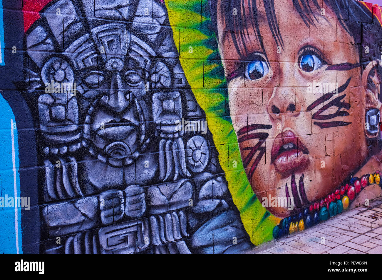 View of colorful street art, a small kid and Mayan symbols, shot in the streets of Malaga in Andalusia, Spain, near the plaza de la Merced Stock Photo