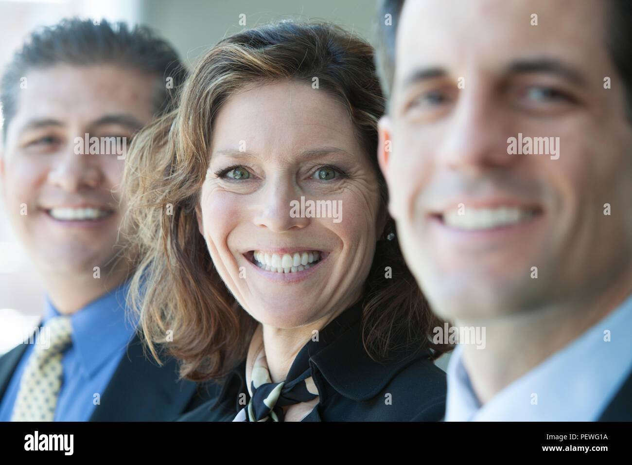A closeup portrait of a row of multi ethnic business people, with focus on the Caucasian businesswoman. Stock Photo