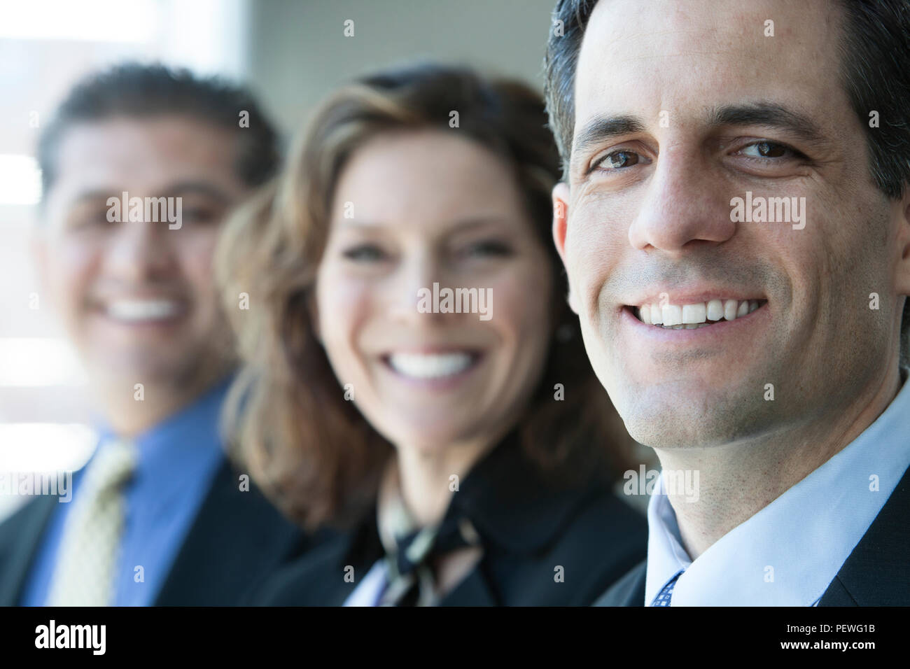 A closeup portrait of a row of multi ethnic business people, with focus on the Caucasian businessman. Stock Photo