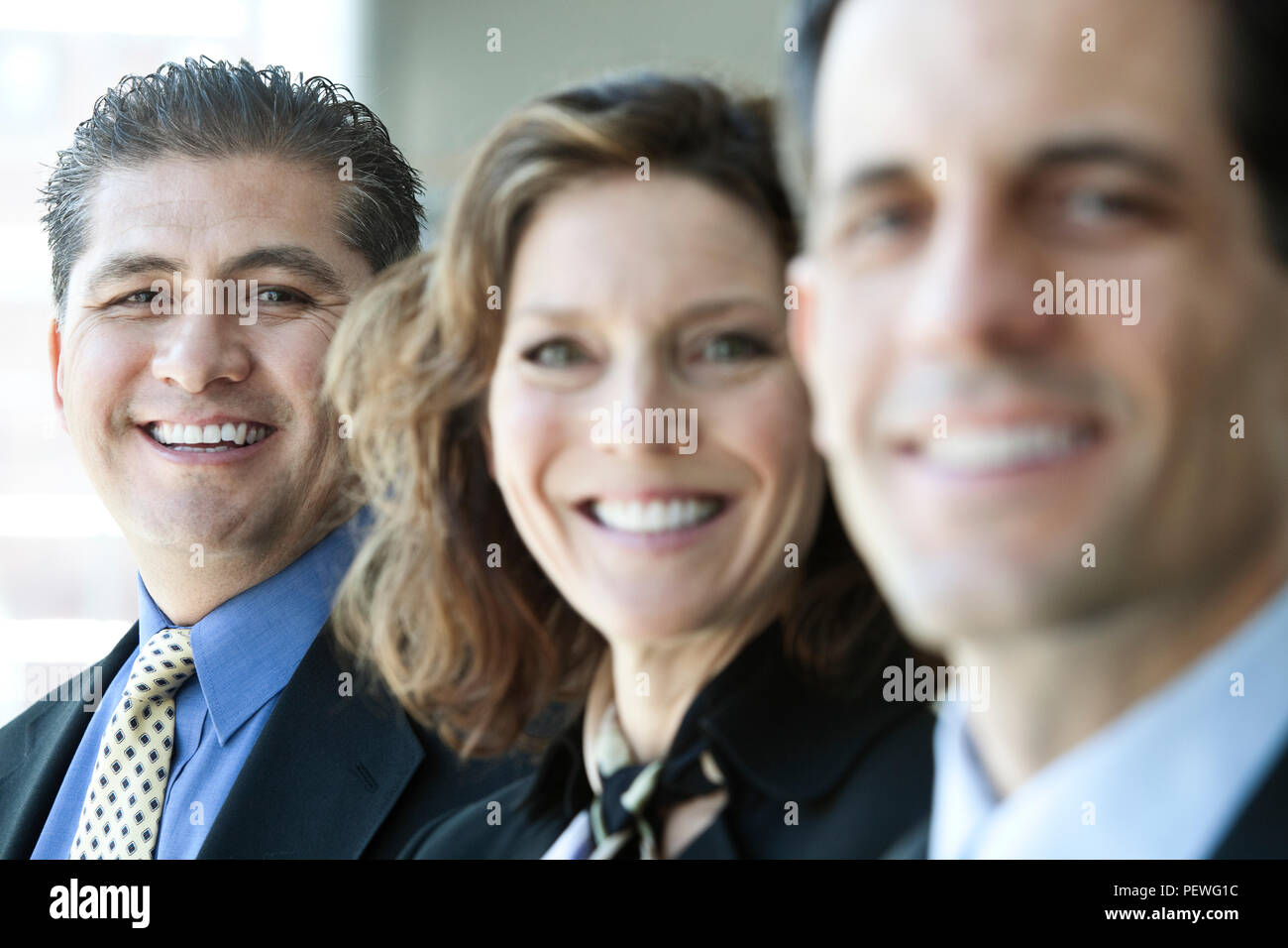 A closeup portrait of a row of multi ethnic business people, with focus on the hispanic businessman. Stock Photo