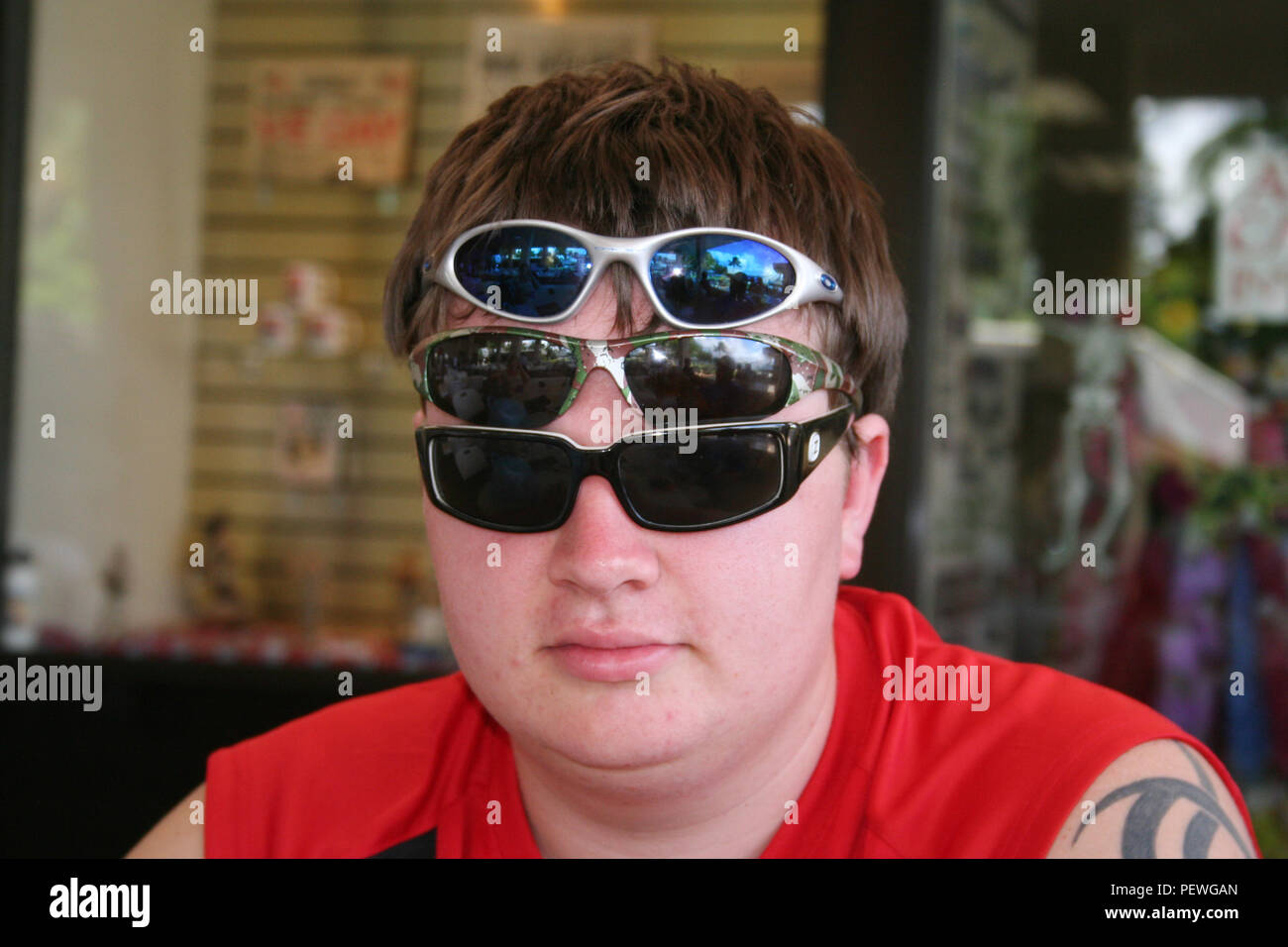 Funny shot of youth wearing three pairs of sunglasses, Hawaii, USA