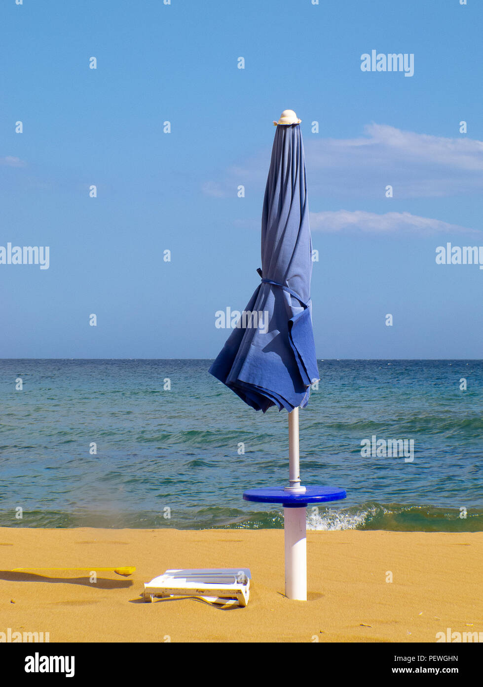 Calabria (Italy): closed beach umbrella with sky and blue sea in background Stock Photo