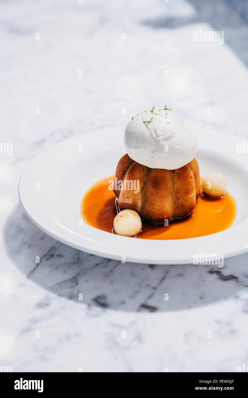 Rum Baba cake with banana caramel and lime ice cream Stock Photo