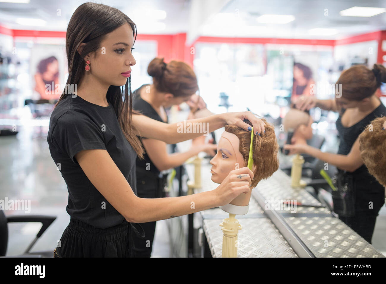 Hairdressers Training With Maniqui Heads In Barber Shop School