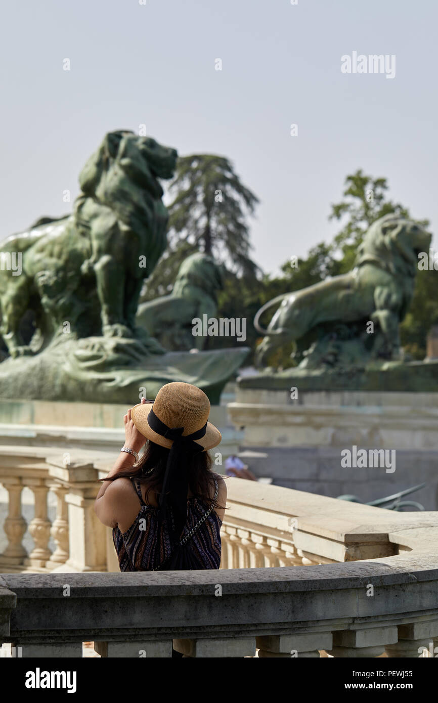 A tourist taking photographs in the Parque del Retiro in central Madrid. Stock Photo