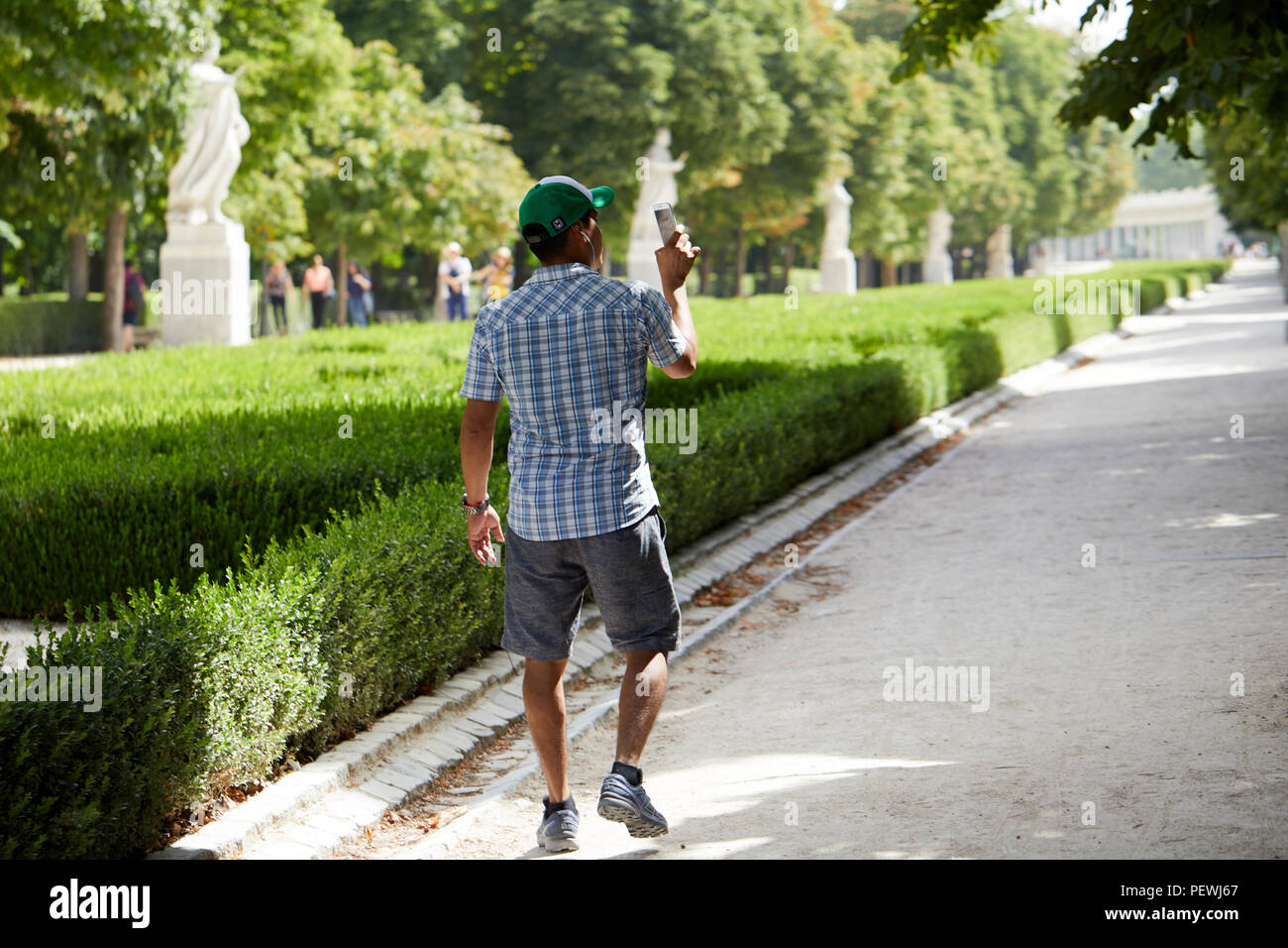 A visitor takes photos in El Parque del Buen Retiro, Madrid. Stock Photo