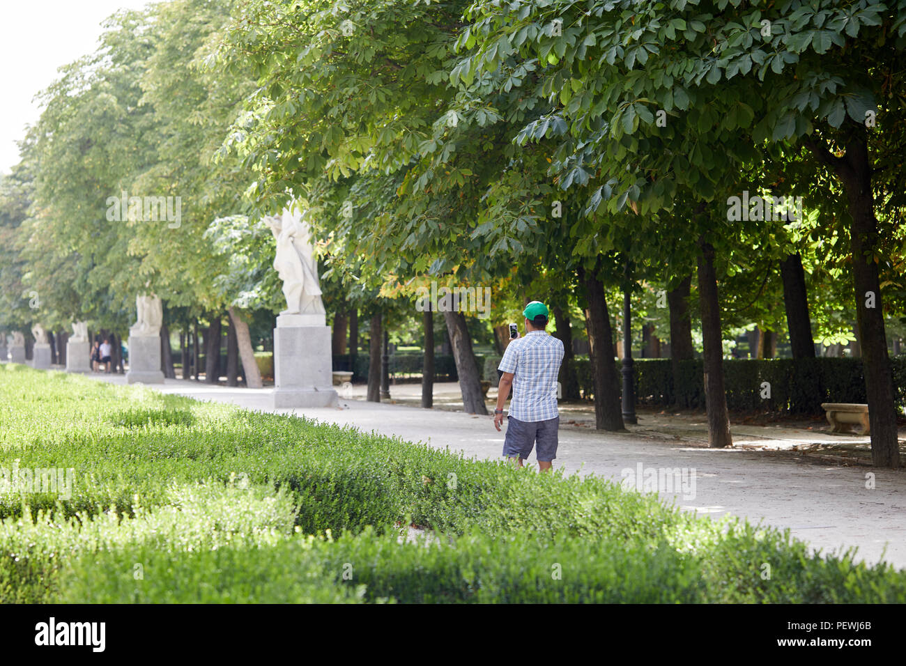 A visitor takes photos in El Parque del Buen Retiro, Madrid. Stock Photo