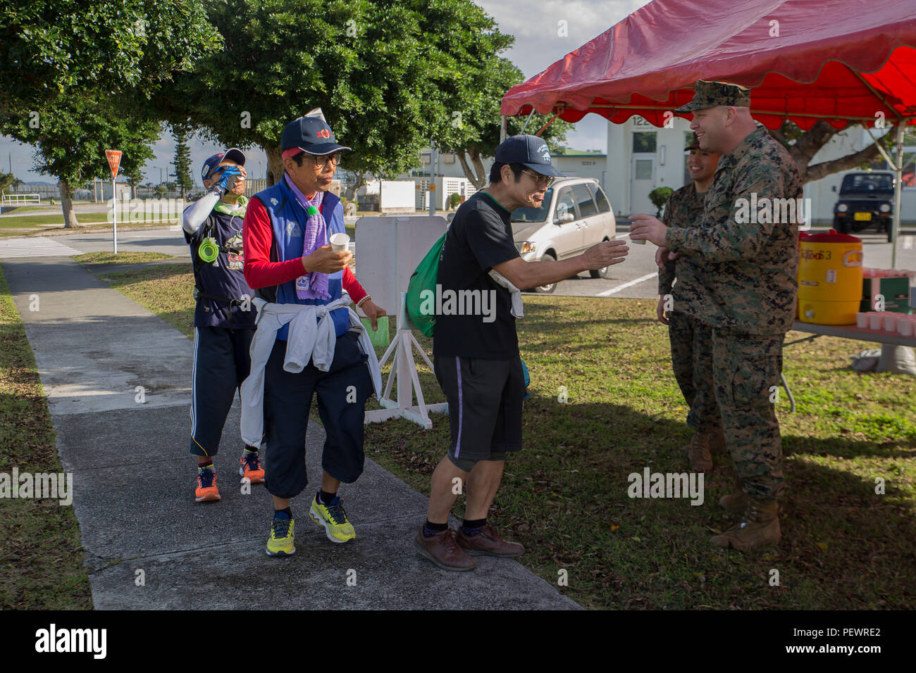 Gunnery Sgt Scott Parker Hands Water To Okinawa Residents At A Water Point During The Tedako Walk 16 Feb 7 Aboard Camp Kinser Okinawa Japan The Two Day Event Promoted Healthy Living While