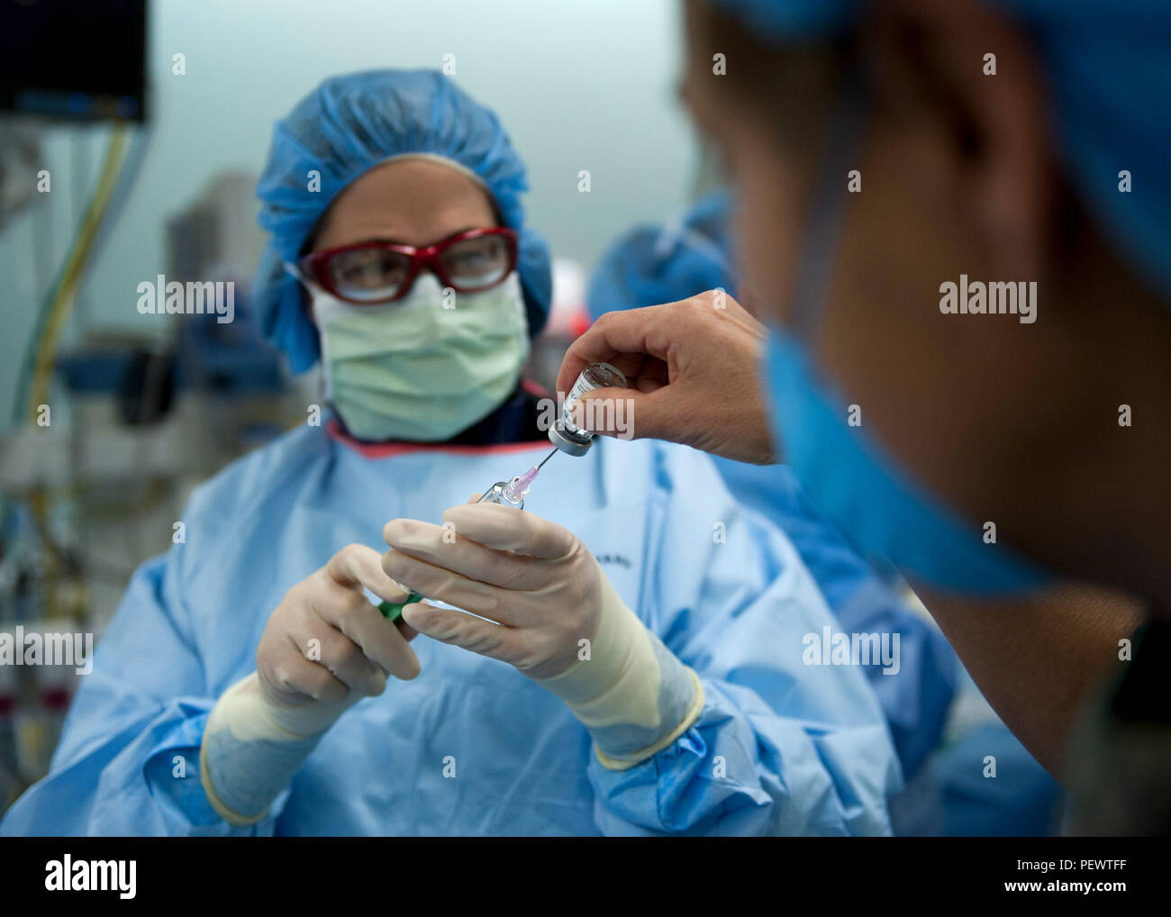 Lt. Col. (Dr.) Maria Lahti, the 96th Medical Operations Squadron's chief  cardiologist, draws medication from a nurse during a cardiac  catheterization Jan. 14 at Eglin Air Force Base, Fla. Lahti drew the