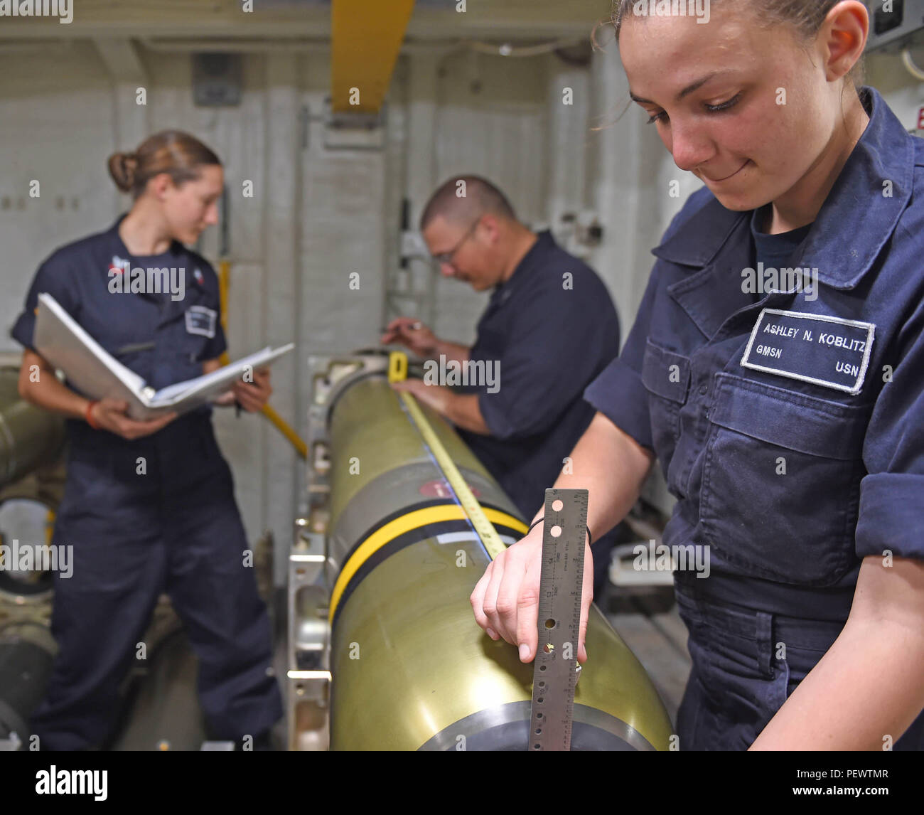 160209-N-KM939-306 PACIFIC OCEAN (Feb 9, 2016) - Gunner’s Mate Seaman Ashley Koblitz, from Memphis, Texas, measures an MK-54 torpedo in preparation for banding in the weapons locker aboard the guided-missile destroyer, USS Stockdale (DDG 106). Providing a combat-ready force to protect collective maritime interests, Stockdale, assigned to the Stennis strike group, is operating as part of the Great Green Fleet on a regularly scheduled Western Pacific deployment. (U.S. Navy photo by Mass Communication Specialist 3rd Class David A. Cox/Released) Stock Photo