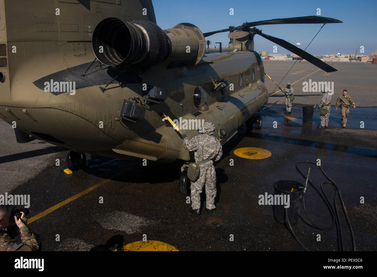 Army Reserve Chemical, Biological, Radiological and Nuclear specialists in the 366th Chemical Co., based out of Savannah, Ga., spray down a CH-47 Chinook helicopter belonging to Company B, 1st Battalion, 168th Aviation Regiment, 40th Combat Aviation Brigade, at Camp Arifjan, Kuwait, Feb. 9. CBRN procedures are covered by Camp Arifjan’s pre-accident plan, which covers a wide range of emergencies that could occur during operations. (Photo by Staff Sgt. Ian M. Kummer, 40th Combat Aviation Brigade Public Affairs) Stock Photo