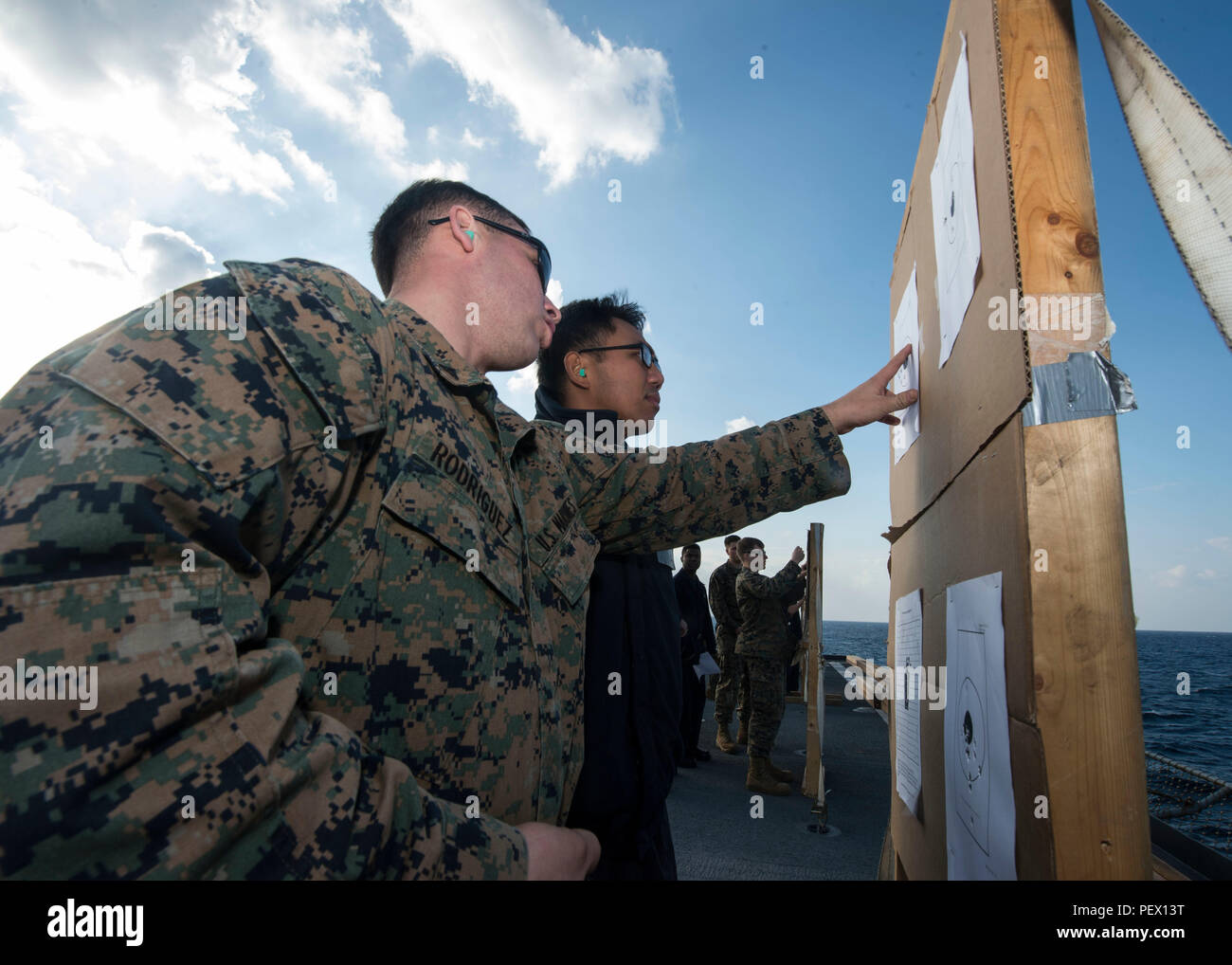 EASTERN COAST OKINAWA (Feb. 11, 2016) –Lance Cpl. Kenneth Rodriguez, left, assigned to the 31st Marine Expeditionary Unit (MEU), and Boatswain’s Mate 2nd Class Ian P. Sarreal tally a score sheet during a live-fire exercise on the flight deck of amphibious dock landing ship USS Germantown (LSD 42). Germantown is assigned to the Bonhomme Richard Amphibious Ready Group (ARG) and is participating in amphibious integration training (AIT) and a certification exercise (CERTEX) with the embarked 31st MEU. (U.S. Navy photo by Mass Communication Specialist 3rd Class James Vazquez/Released) Stock Photo