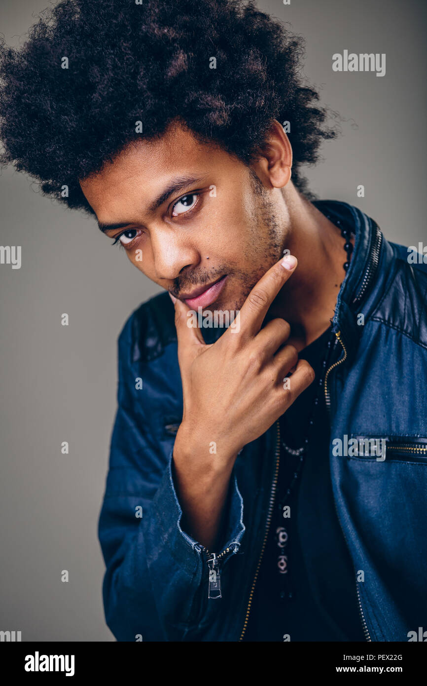 Positive guy with African hairstyle and dark skinlooking cheerfully into  camera. Young dark-skinned male with smile dressed elegantly Stock Photo -  Alamy