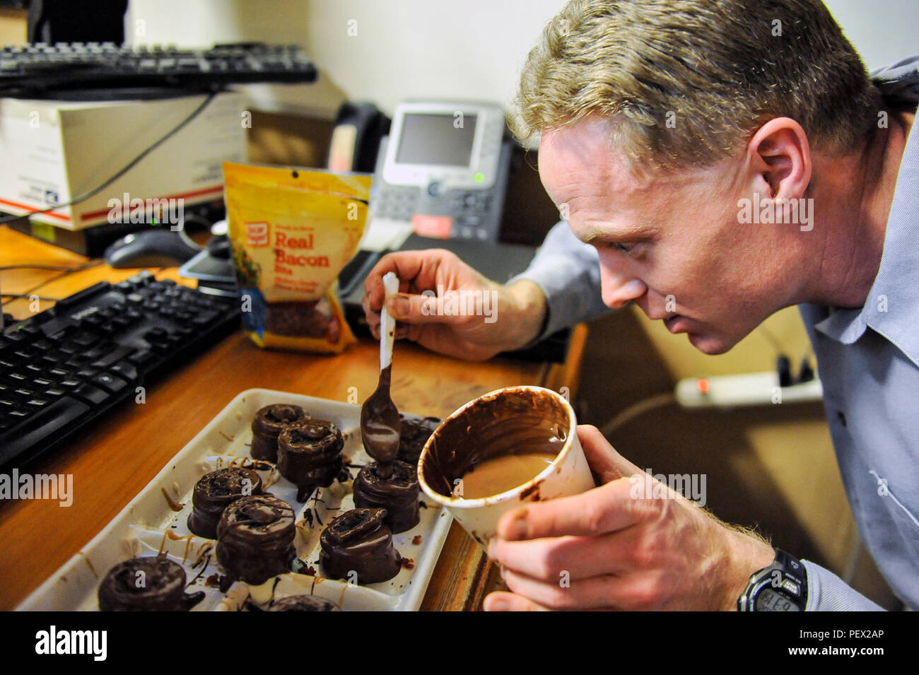 Dan Johnson, 455th Expeditionary Mission Support Group contract augmentation program manager and treat maker, makes a batch of 'Dead Elvis' at Bagram Air Field, Afghanistan, on Feb. 16, 2016. The 'Dead Elvis' is a deployed confection created using peanut butter Oreos, bacon, and chocolate. (U.S. Air Force photo by Tech. Sgt. Nicholas Rau) Stock Photo