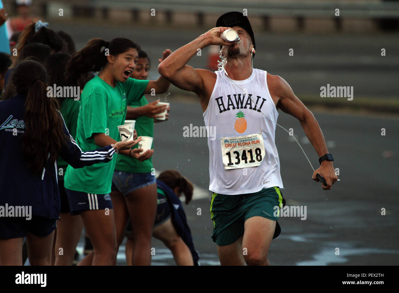 Runners pass a water checkpoint during the Great Aloha Run in Pearl Harbor, Hawaii, Feb. 15, 2016.  The Great Aloha Run is an annual charity event with more than 30,000 participants and 6,000 military service members. Marines participated in the Sounds of Freedom portion of the race, where they ran in memory of the fallen Marines from Marine Heavy Helicopter Squadron 463. (U.S. Marine Corps photograph by Staff Sgt. Jason W. Fudge) Stock Photo