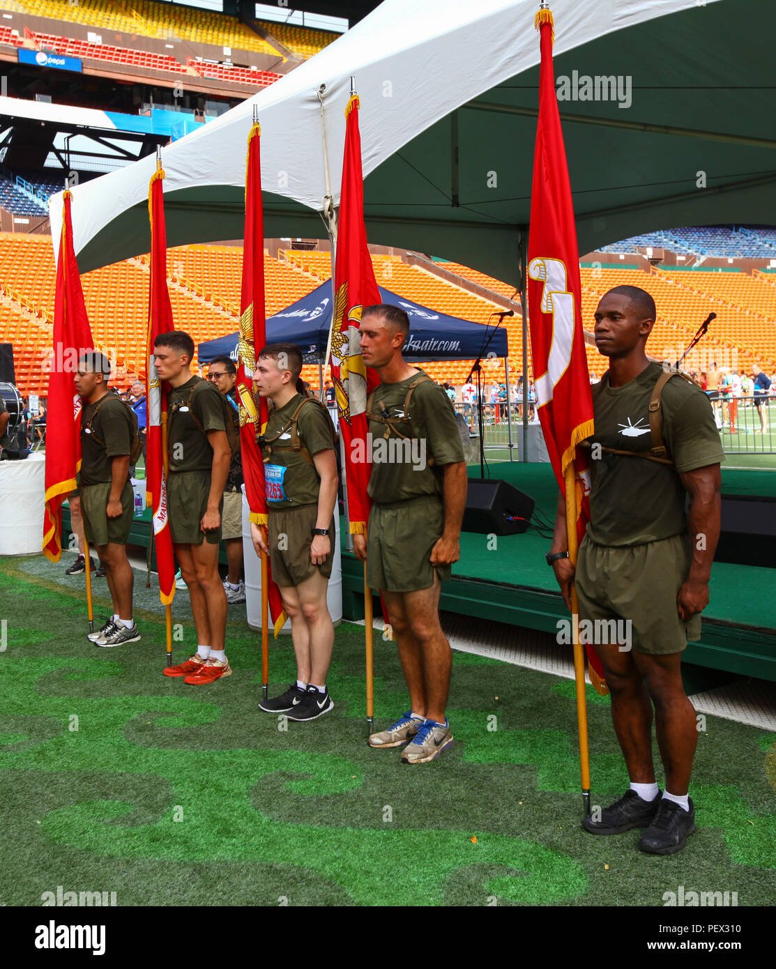 U.S. Marines from U.S. Marine Corps Forces, Pacific and Marine Corps Base Hawaii stand with the Marine Corps flag inside the Aloha Stadium, Hawaii, Feb. 15, 2016. The Great Aloha Run is an annual charity event with more than 30,000 participants and 6,000 military service members. Marines participated in the Sounds of Freedom portion of the race, where they ran in memory of the fallen Marines from Heavy Helicopter Squadron 463. (U.S. Marine Corps photograph by Lance Cpl. Patrick Mahoney) Stock Photo
