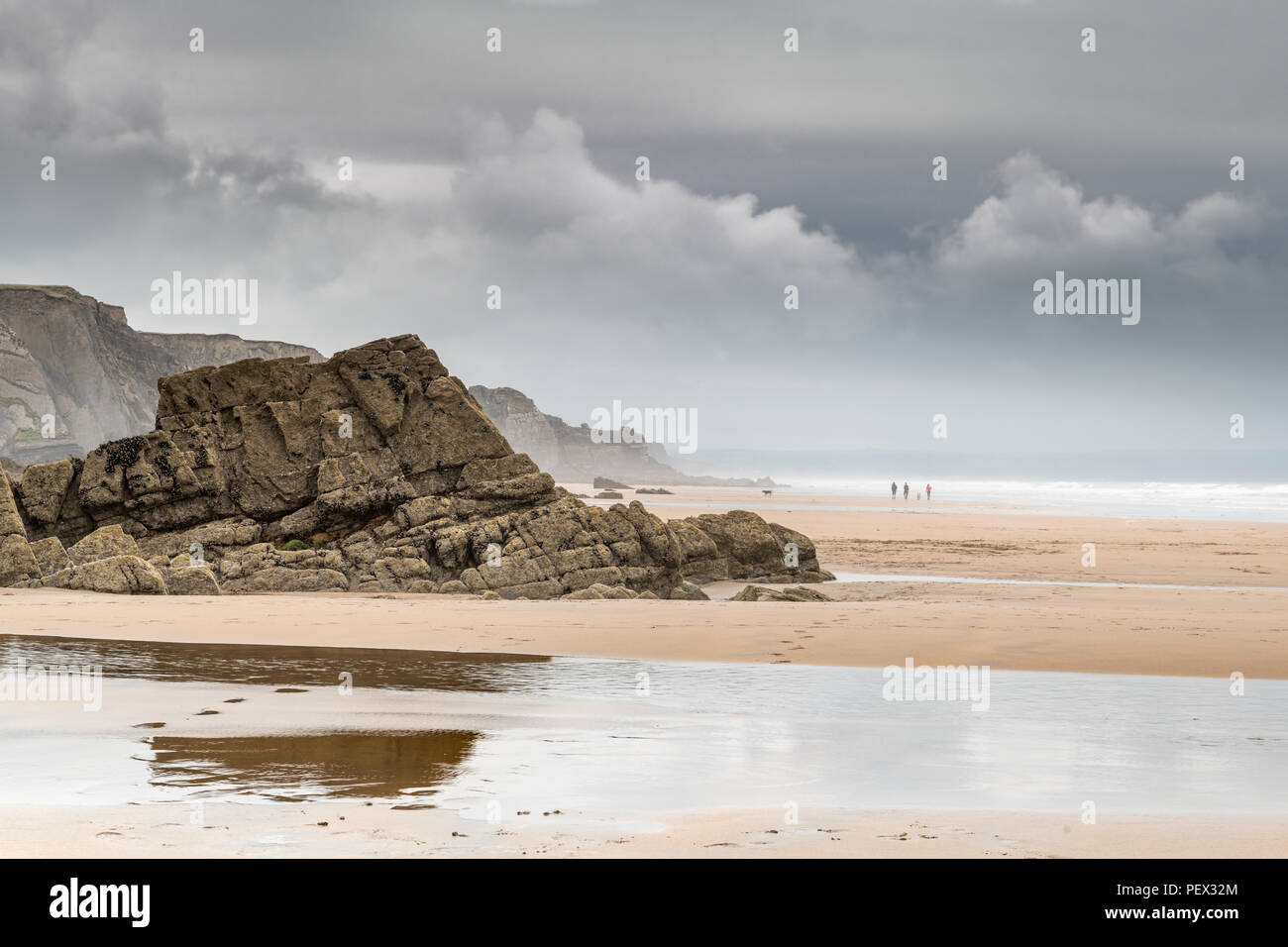 Increasing sea mist and gathering storm clouds form over the expansive open beach at Sandymouth in North Cornwall. Stock Photo