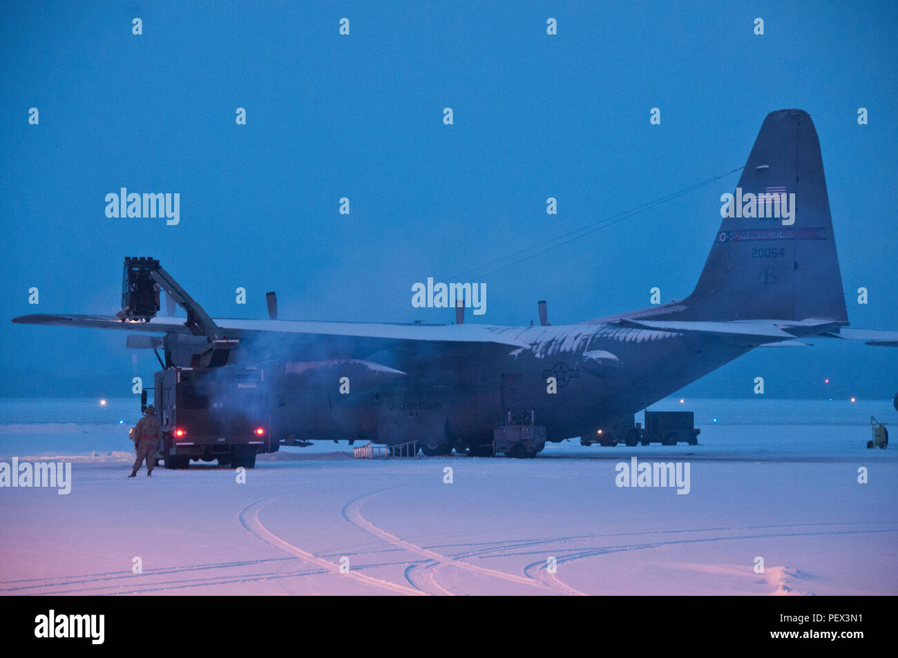 Ohio Air National Guard members work early morning,  Feb. 16, 2016, to remove snow from the flightline and fleet of C-130H Hercules at the 179th Airlift Wing, Mansfield, Ohio. The Ohio Air National Guard unit is always on mission to respond with highly qualified citizen-airmen to execute Federal, State and community missions. (U.S. Air National Guard photo by Tech. Sgt. Joe Harwood/Released) Stock Photo