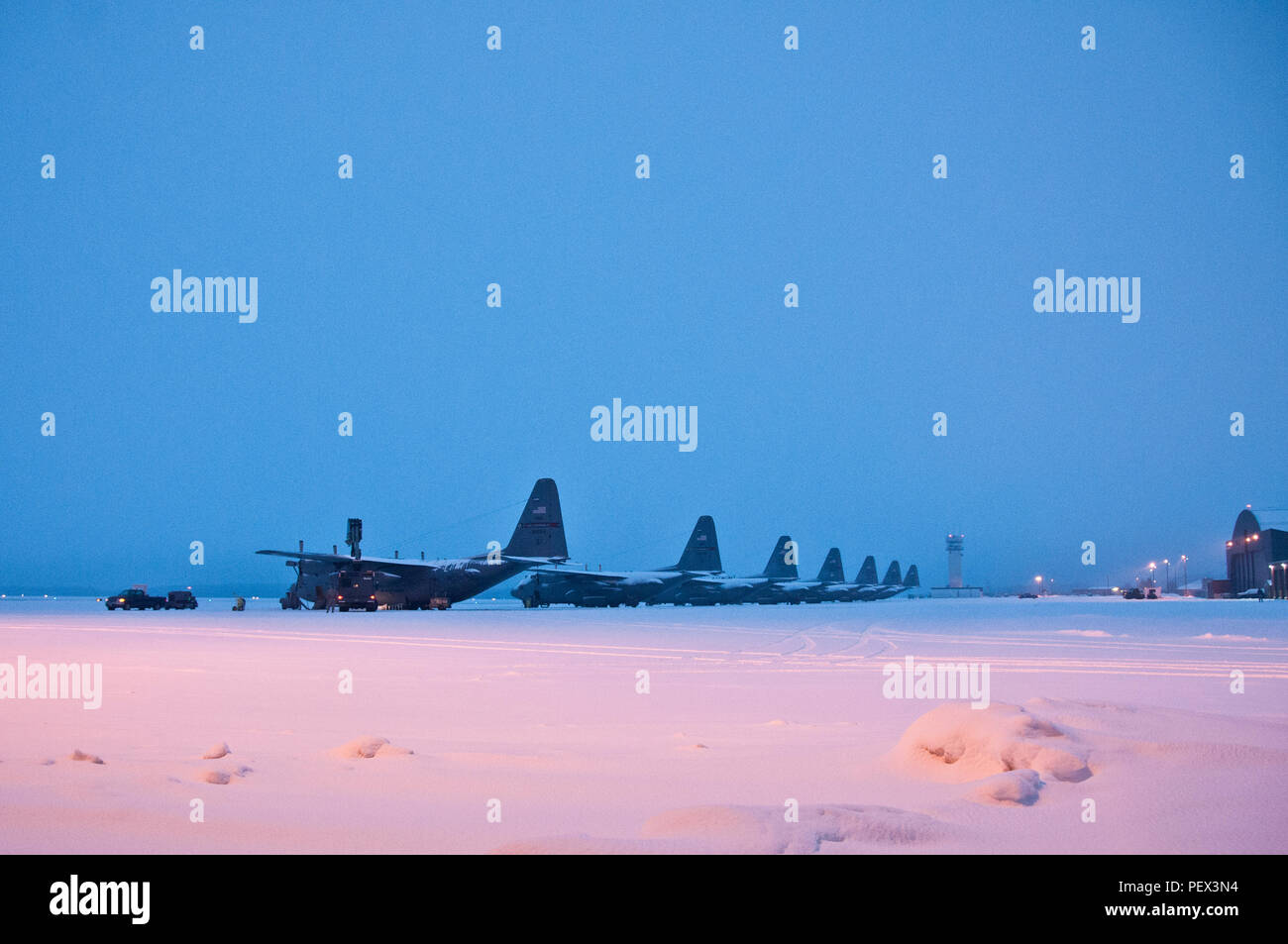 Ohio Air National Guard members work early morning,  Feb. 16, 2016, to remove snow from the flightline and fleet of C-130H Hercules at the 179th Airlift Wing, Mansfield, Ohio. The Ohio Air National Guard unit is always on mission to respond with highly qualified citizen-airmen to execute Federal, State and community missions. (U.S. Air National Guard photo by Tech. Sgt. Joe Harwood/Released) Stock Photo