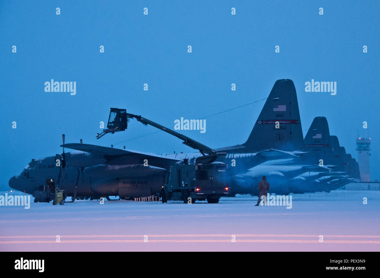 Ohio Air National Guard members work early morning,  Feb. 16, 2016, to remove snow from the flightline and fleet of C-130H Hercules at the 179th Airlift Wing, Mansfield, Ohio. The Ohio Air National Guard unit is always on mission to respond with highly qualified citizen-airmen to execute federal, state and community missions. (U.S. Air National Guard photo by Tech. Sgt. Joe HarwoodReleased) Stock Photo