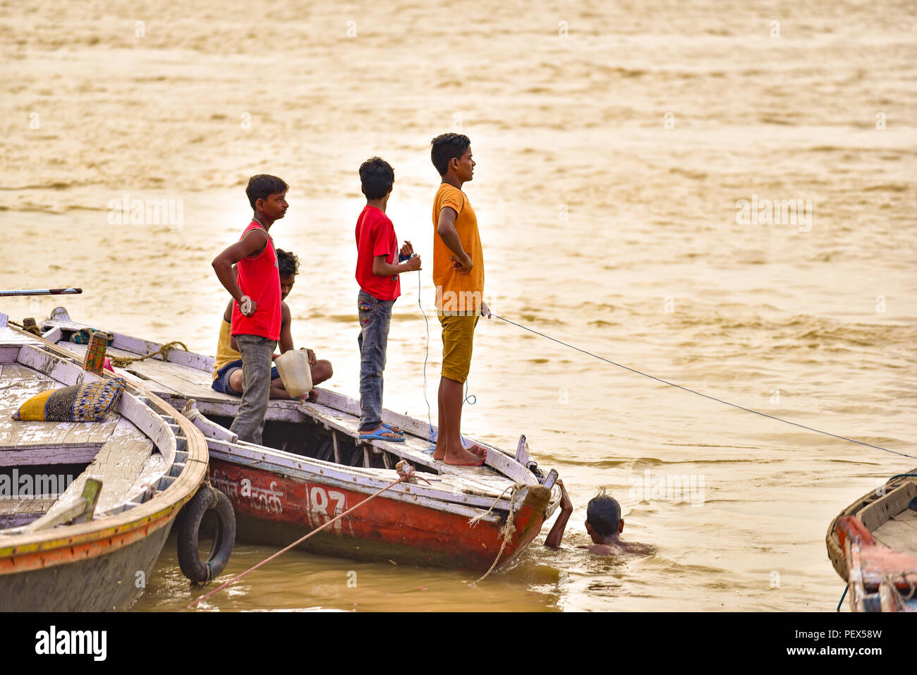 Indian people on boats on Ganges river in the morning with golden light Stock Photo
