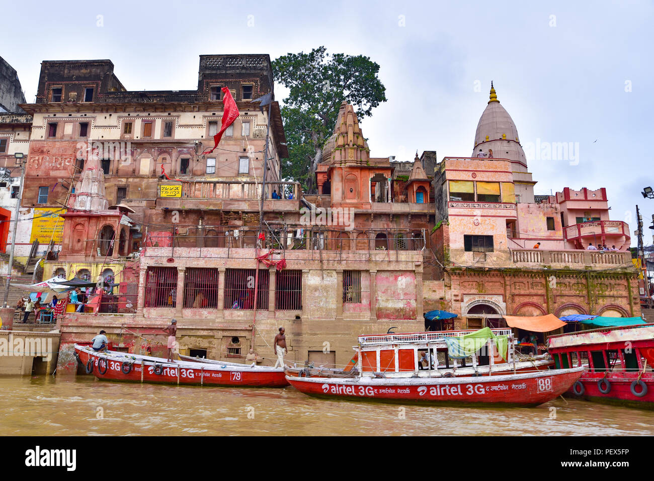 Buildings and ghat along Ganges river with people and boats Stock Photo