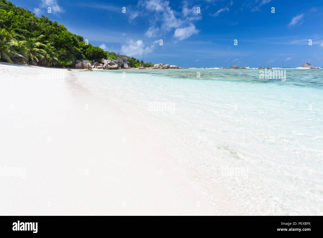 The beautiful tropical beach Anse Source D'Argent in La Digue, Seychelles with crystal clear water, granite rocks and palm trees Stock Photo