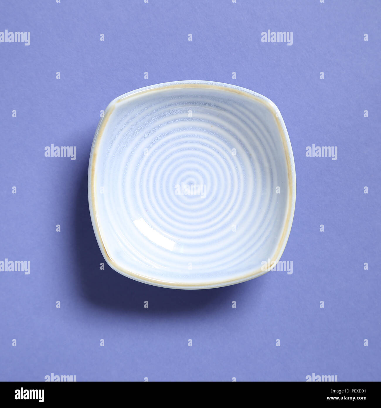 Blue dish isolated on purple background Stock Photo