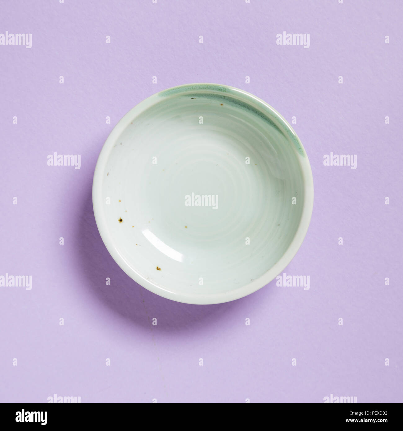 Green dish isolated on purple background Stock Photo