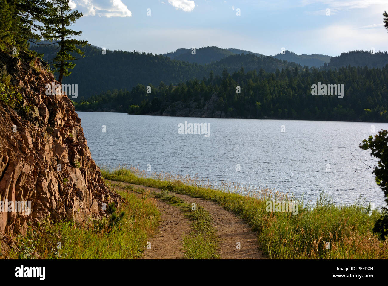 Curved Dirt Road on a Lake Shore in the Mountains Stock Photo