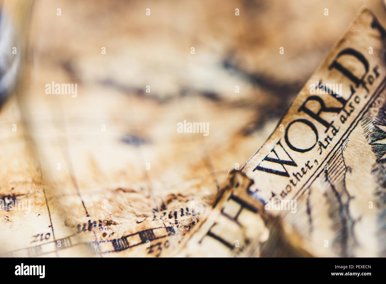 View through magnifier on old map, showing "World" word. Stock Photo