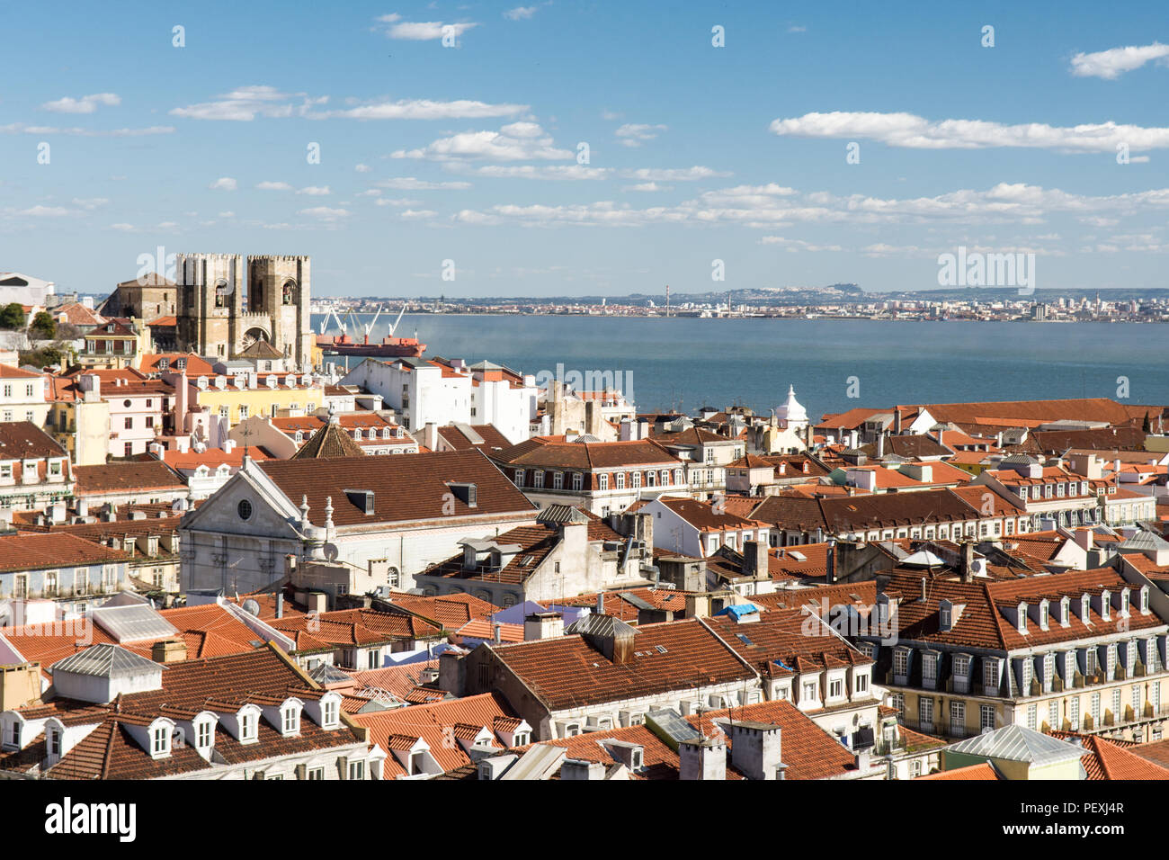 The Se de Lisboa cathedral stands out in the cityscape of rooftops of Lisbon, with the Tagus River estuary behind, viewed from the Elevador de Santa J Stock Photo