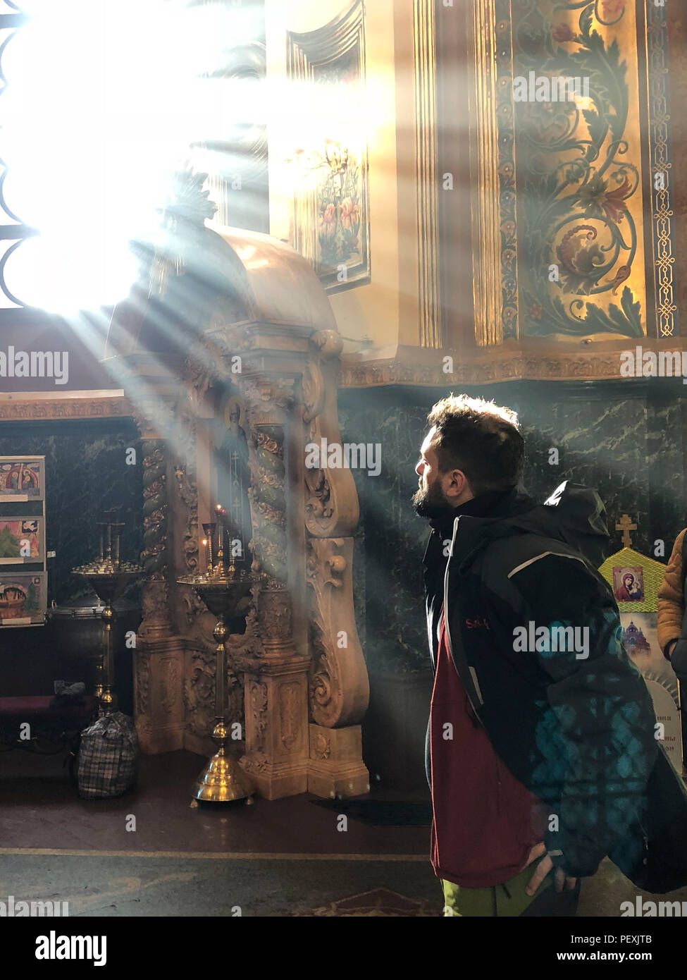 Man looking at sunbeams shining through window in church, Irkutsk, Irkutsk Oblast, Siberia, Russia Stock Photo