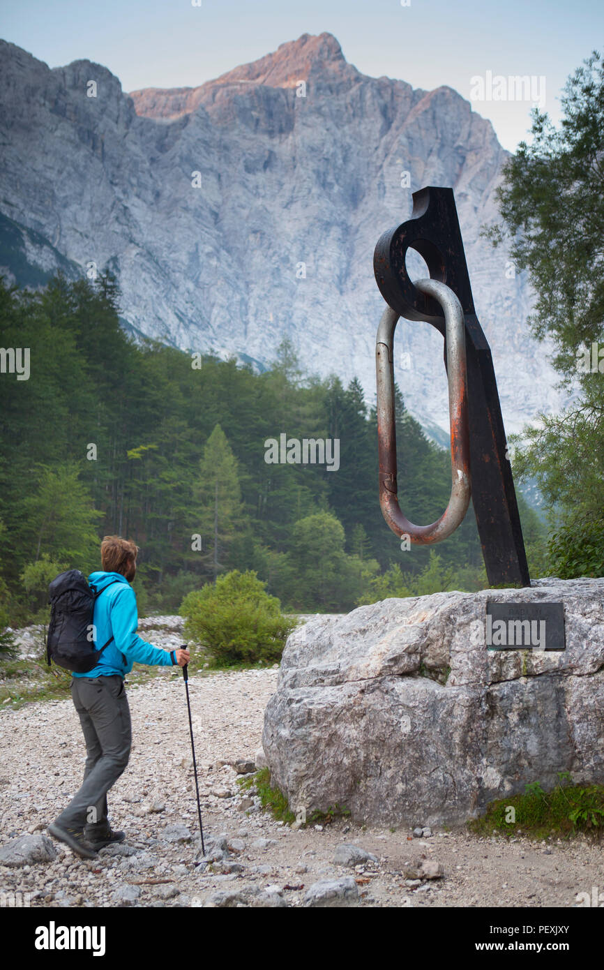 Mountain guide walking by monument of carabiner, Triglav, Slovenia Stock Photo