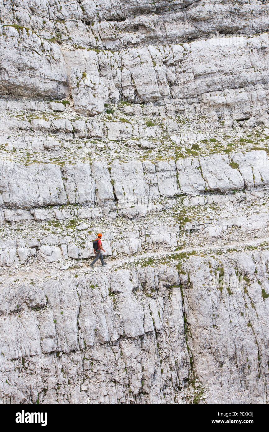 Mountain guide walking across rocky mountain face during climb of Triglav, Slovenia Stock Photo